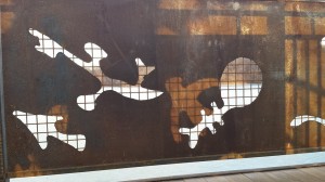 The setting sun shines through a Petroglyph cut-out on one side of the bridge, the image falling between Petroglyph cut-outs on the other side.
